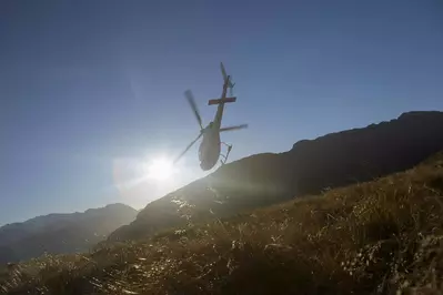 Helicopter flying over field in sunset