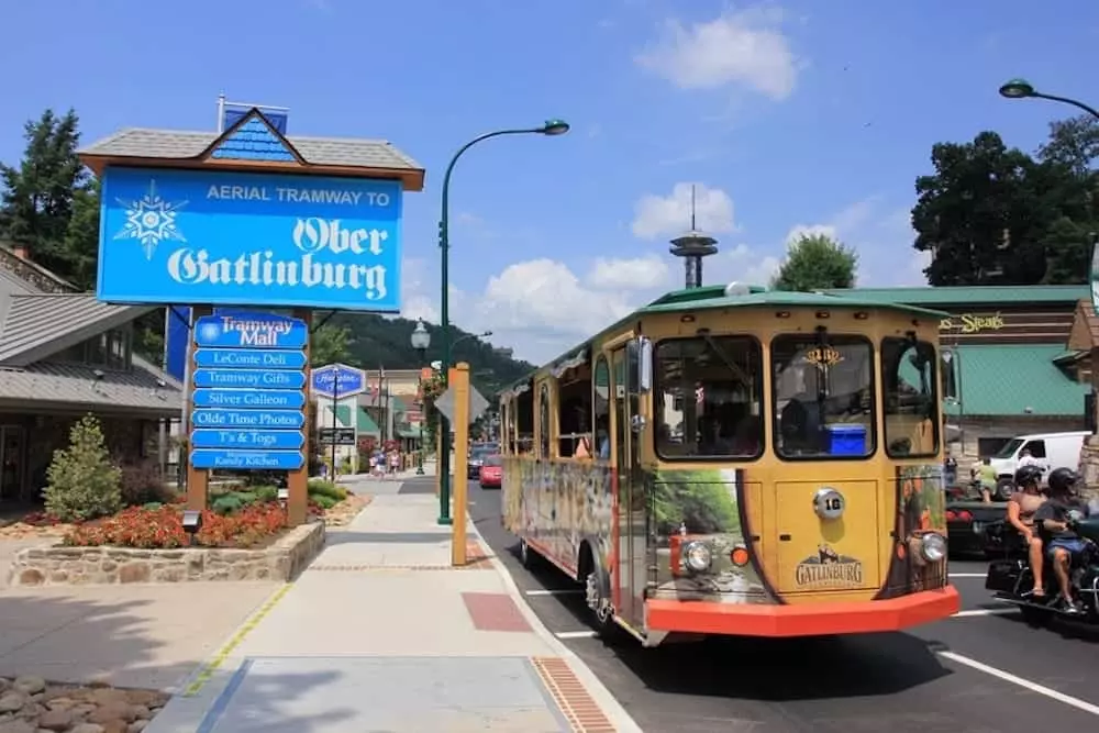 gatlinburg trolley next to the ober gatlinburg sign