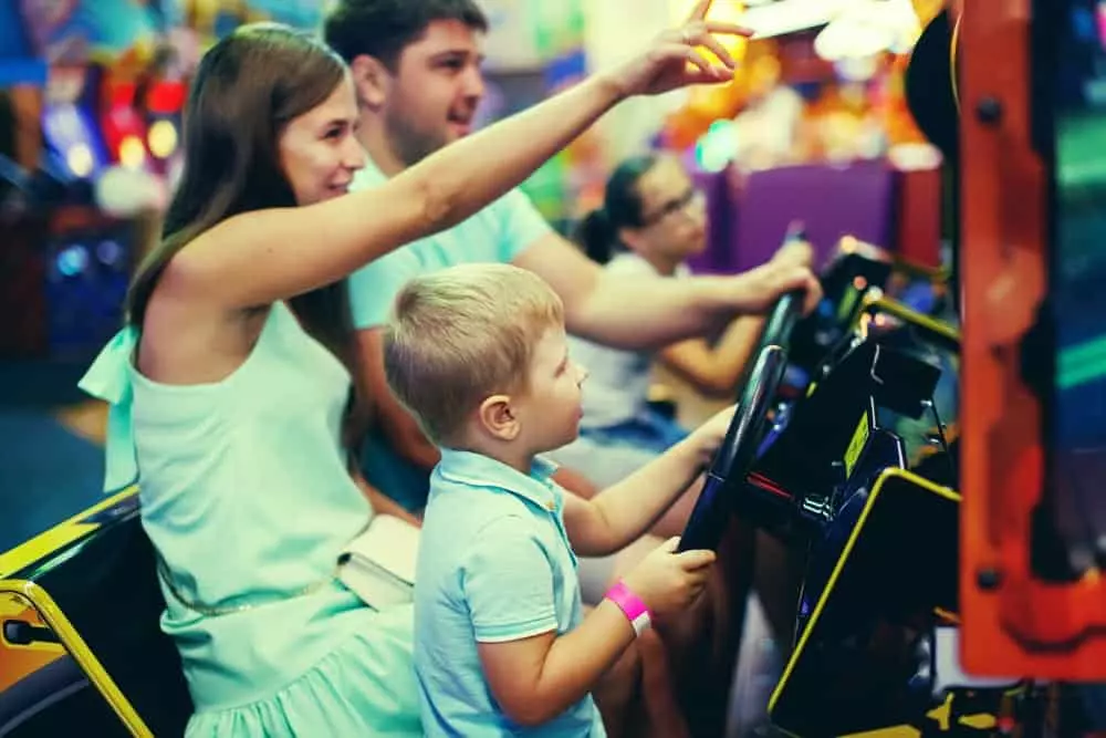 mother and father playing in arcade with son