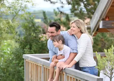 family on deck of cabin in mountains