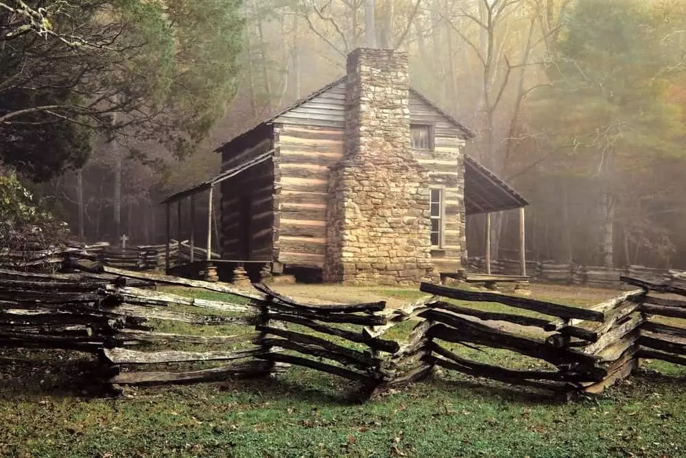 The John Oliver cabin behind a fence in Cades Cove.