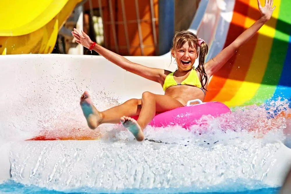 A girl riding a water slide at a water park.