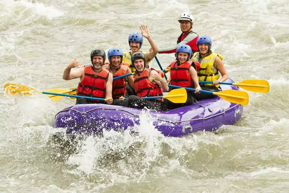 Friends white water rafting on a river.