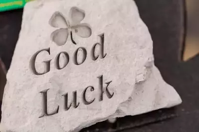 An engraved stone with the phrase good luck and a four-leaf clover.