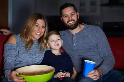 Family watching movie at a cabin