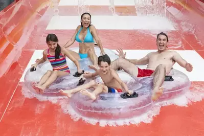 Family tubing down a water slide at Dolly's Splash Country, one of the best things to do in Pigeon Forge in the summer.