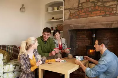 Family playing cards at a table in a cabin