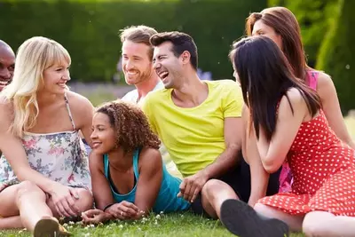 family and friends laughing in grass