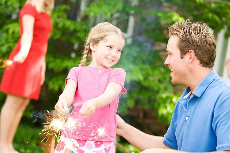 little girl with dad holding sparklers