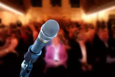 up-close microphone shot with blurred audience in background