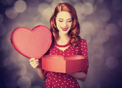 Woman opening a heart-shaped present box