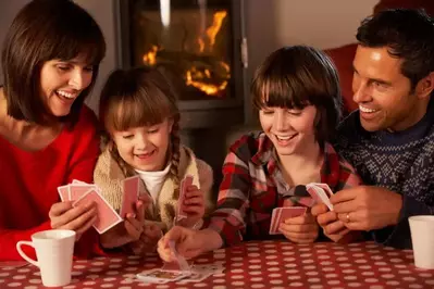 Family playing card games by the fire