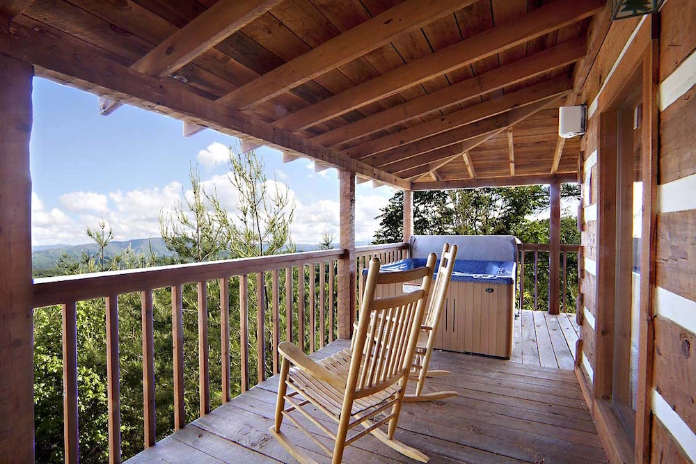Chairs-and-a-hot-tub-on-the-deck-of-the-Knotty-and-Nice-cabin-in-Gatlinburg-with-mountain-views