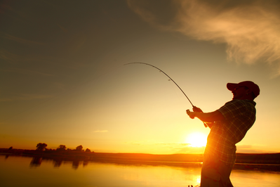 A-man-fishing-in-a-river-at-sunset
