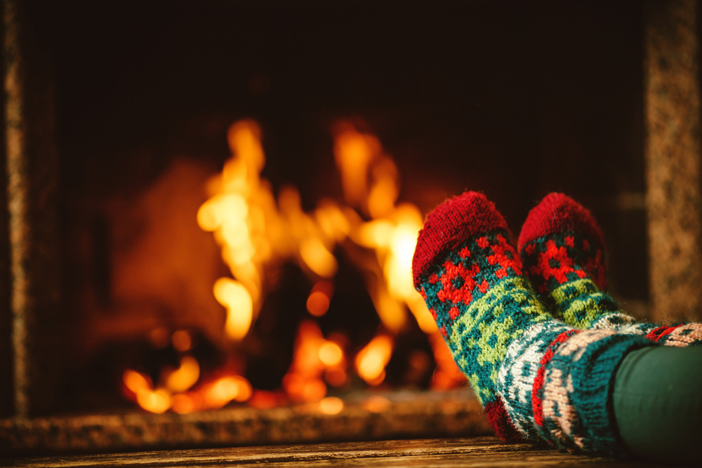 Feet in wool socks relaxing in front of the fireplace.