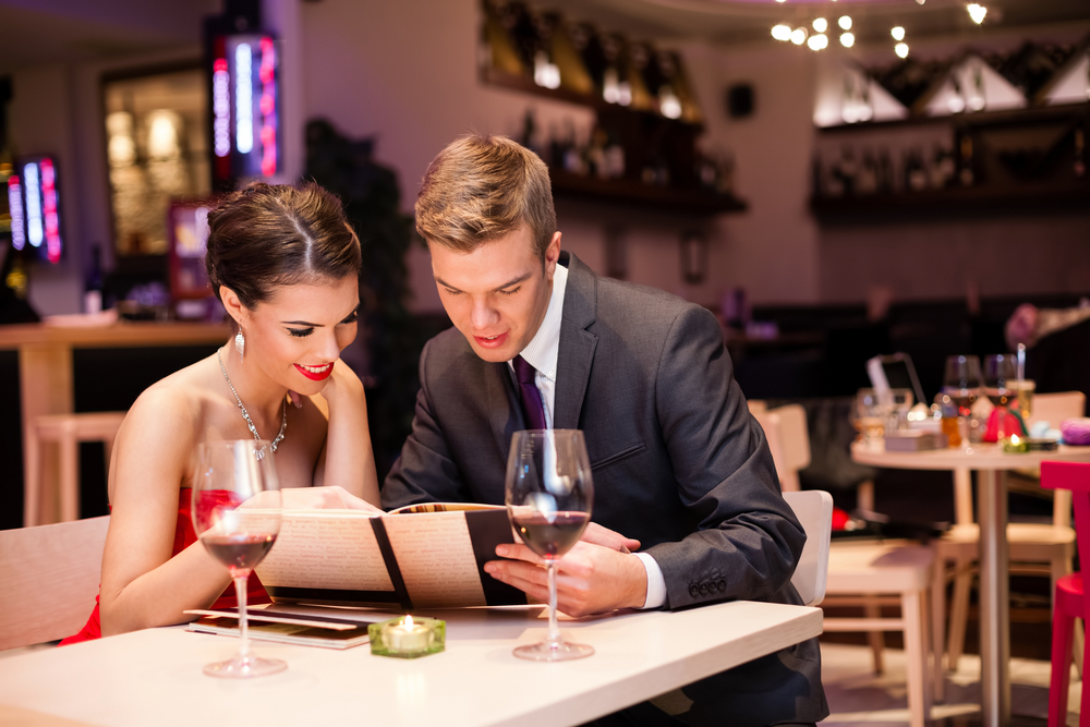 Couple sharing a menu at a romantic restaurant.