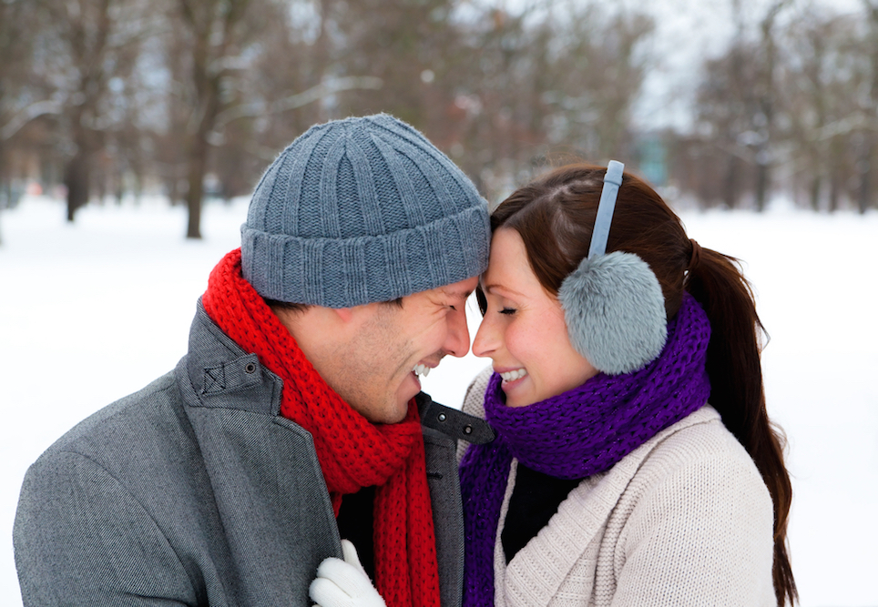 Happy couple sharing a romantic moment outdoors on a snowy day.