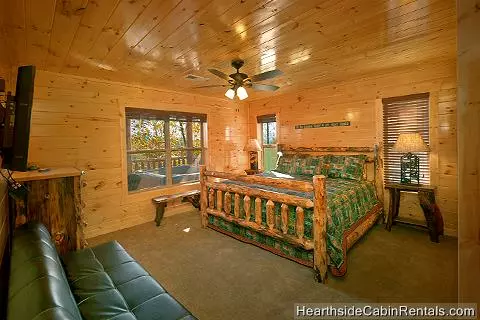 Relaxing king bedroom with flat-screen tv and full-size futon at A Grand View Lodge cabin in Pigeon Forge