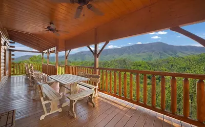 Large wooden deck with picnic table at Majestic View Lodge cabin in Pigeon Forge
