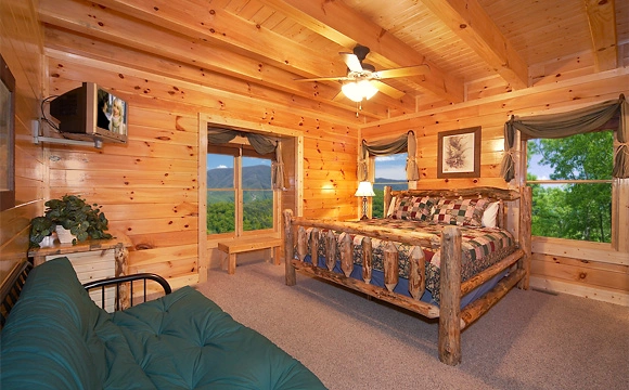 King-size bedroom that overlooks the mountains with full-size futon couch in Majestic View Lodge cabin in Pigeon Forge