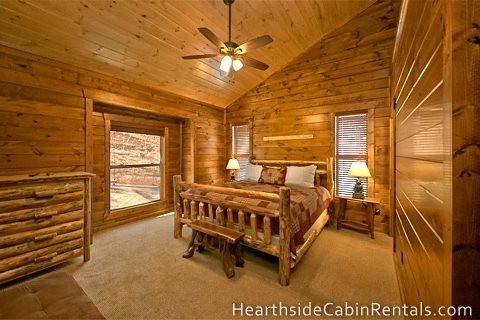 King-size bedroom inside Pigeon Forge cabin with rustic furniture.