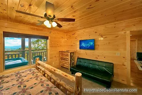 King suite in A View For All Seasons cabin near Gatlinburg with full-size futon couch and tv
