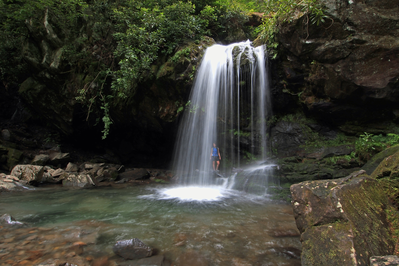 woman walking behind Grotto Falls